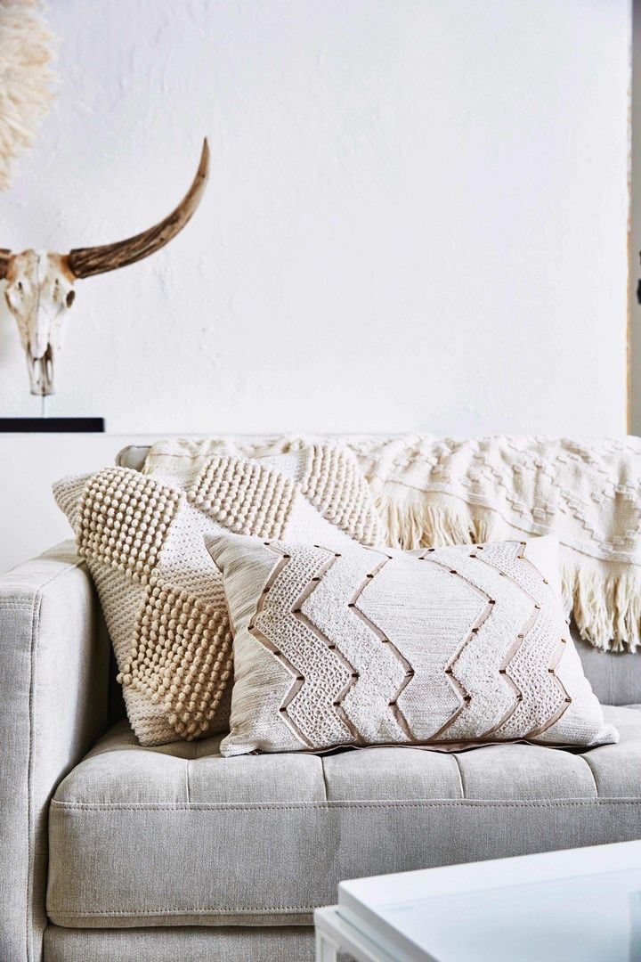 a couch with pillows and a cow skull on the wall