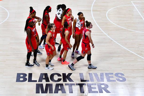 the women's basketball team huddle together on the court