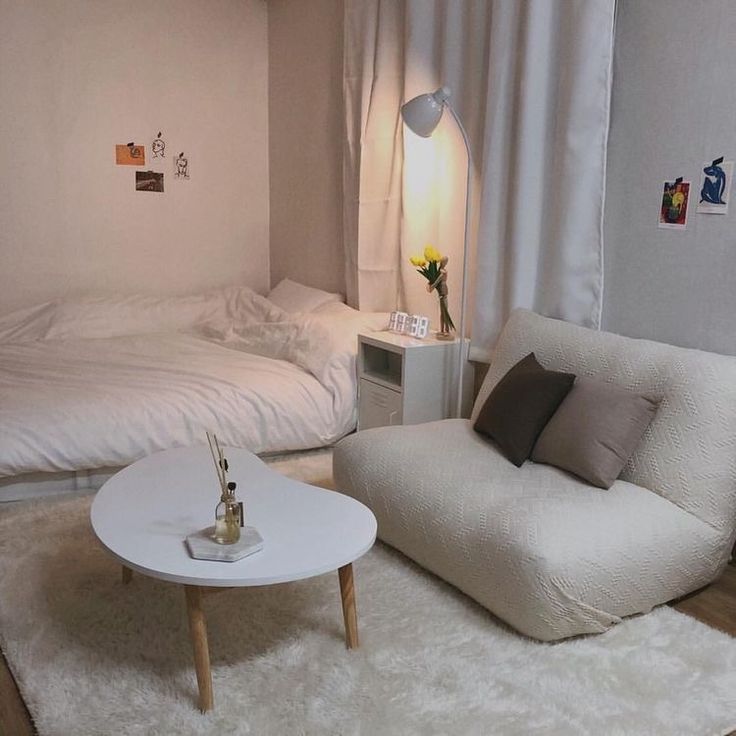 a living room with two beds and a white rug on the floor in front of it