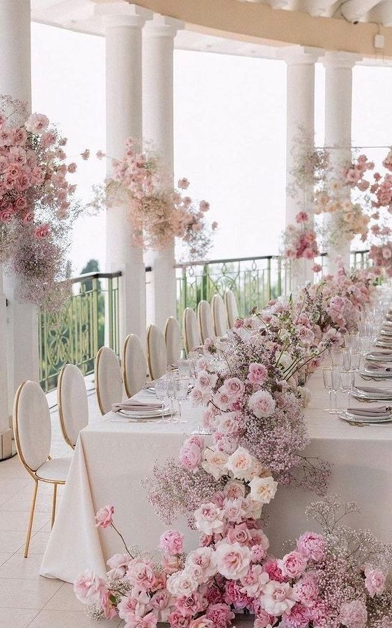 the table is set with white and pink flowers