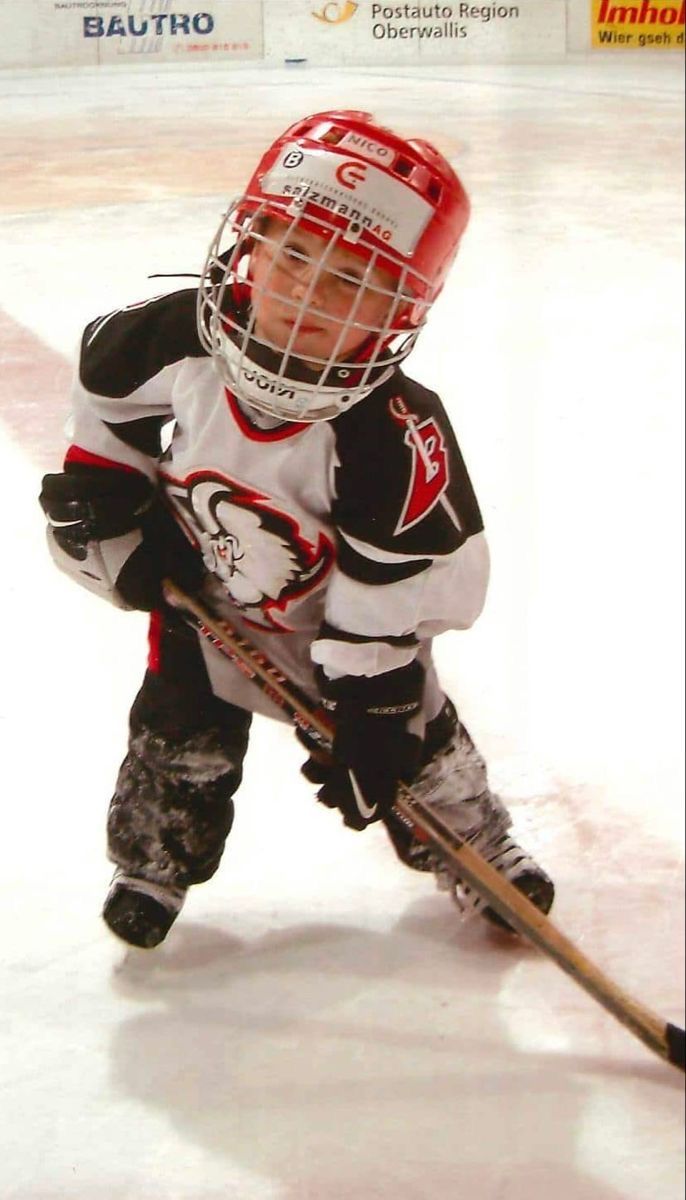 a young boy playing hockey on an ice rink