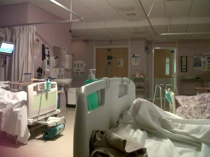 an empty hospital room with medical equipment in the foreground and tv on the wall