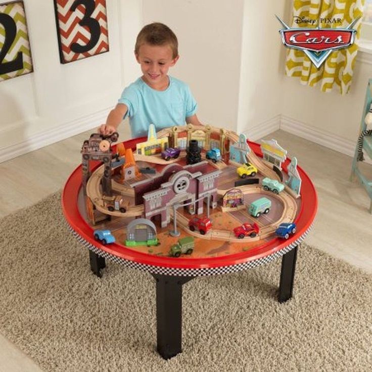 a young boy playing with a toy train set