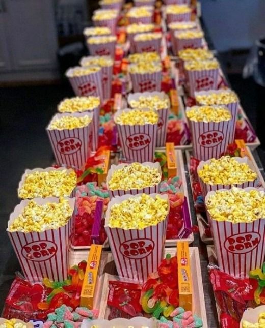 rows of popcorn boxes filled with different types of candy and candies on a table