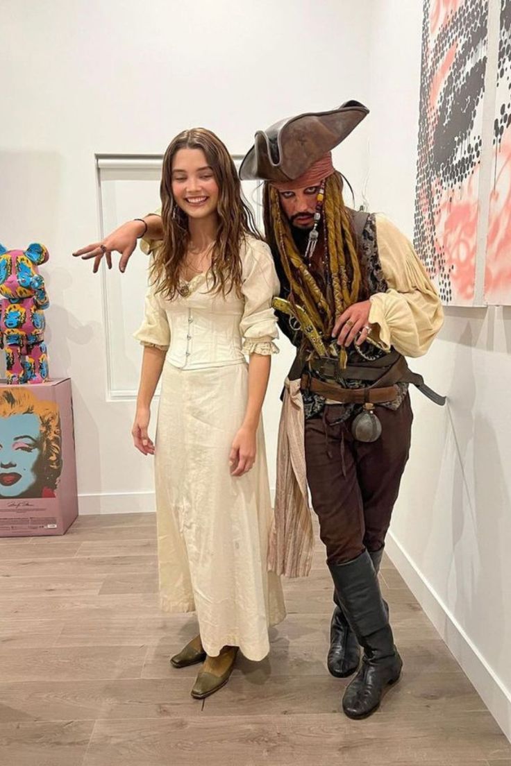 two people dressed up as pirates in an art gallery