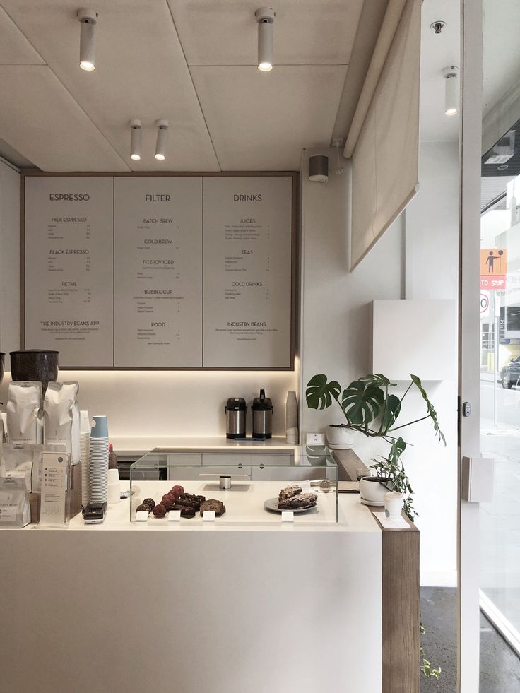 a white counter top sitting inside of a kitchen next to a potted green plant