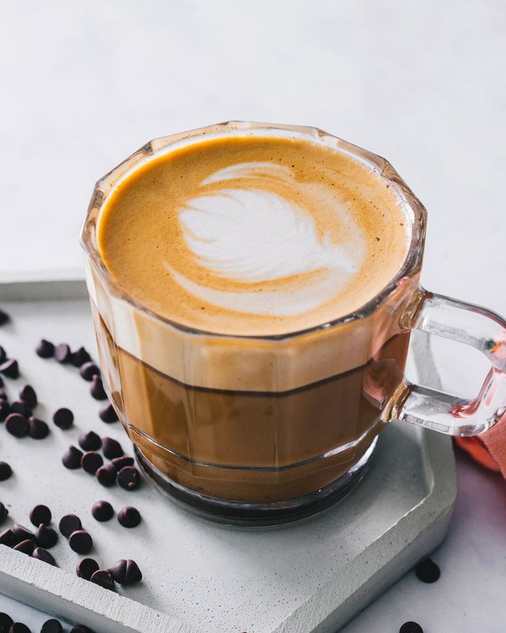 a cappuccino in a glass cup with chocolate chips around it and the caption mocha cappuccino