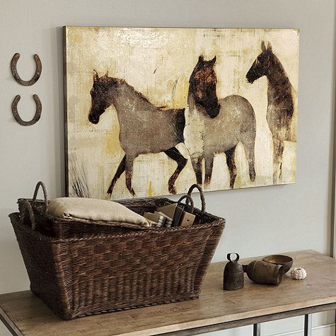 three horses running in the same direction on a wall above a basket and other items