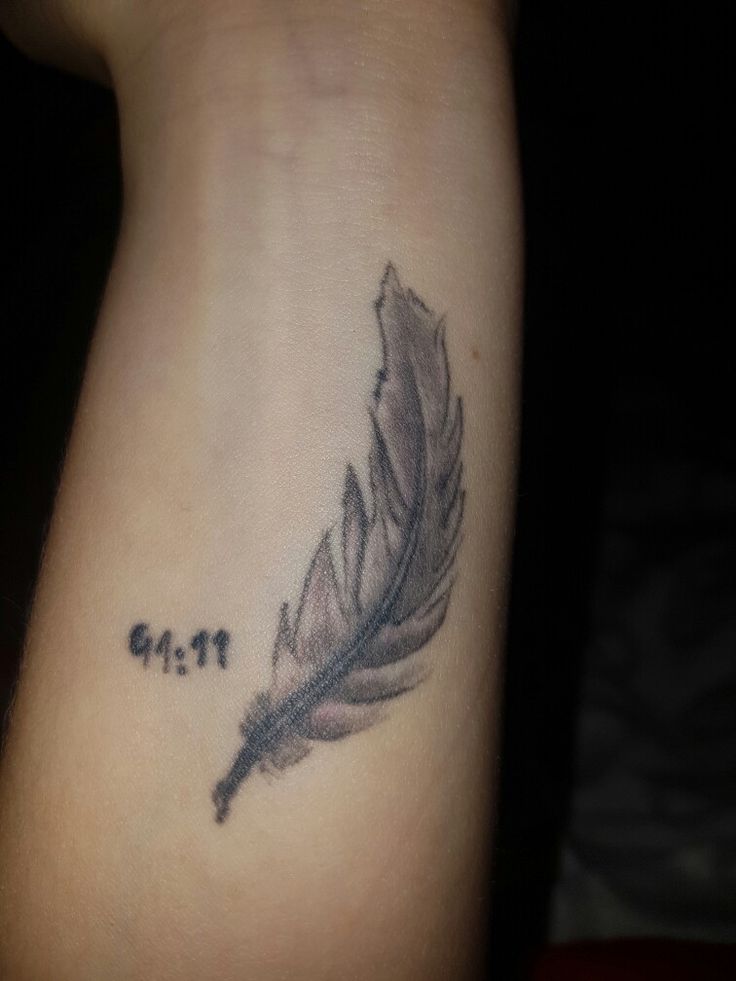 a tattoo with a feather on the arm and words written below it that says get it