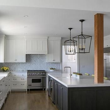 a kitchen with white cabinets and stainless steel appliances in the center, along with an island