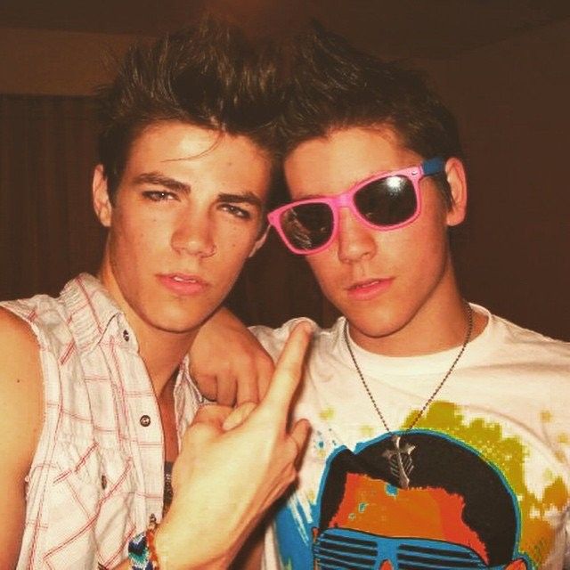 two young men posing for the camera with sunglasses on