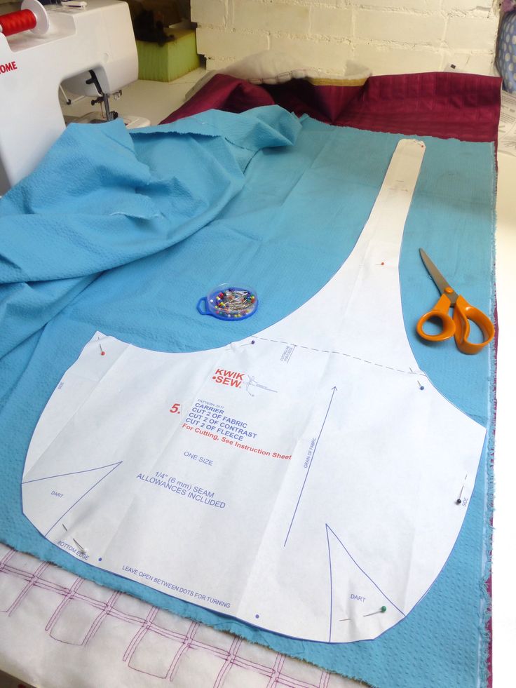 the apron is being sewn on with scissors next to it and some fabric in front