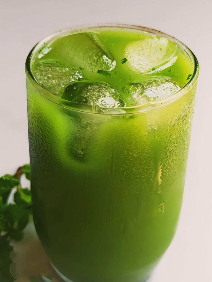 a green drink with ice and garnish on the rim