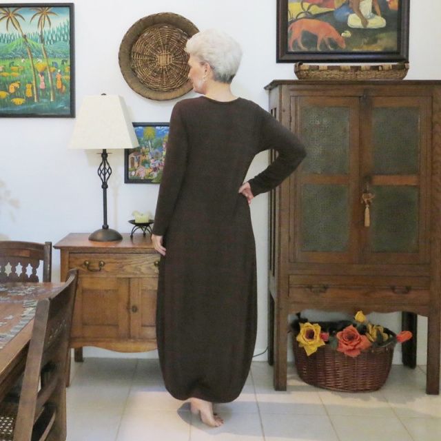 a woman standing in front of a wooden cabinet