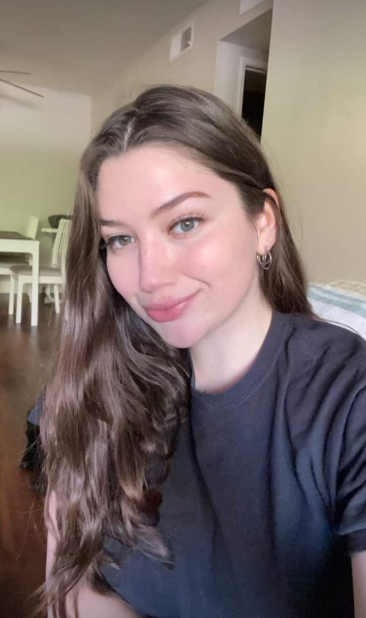 a woman with long hair is smiling for the camera