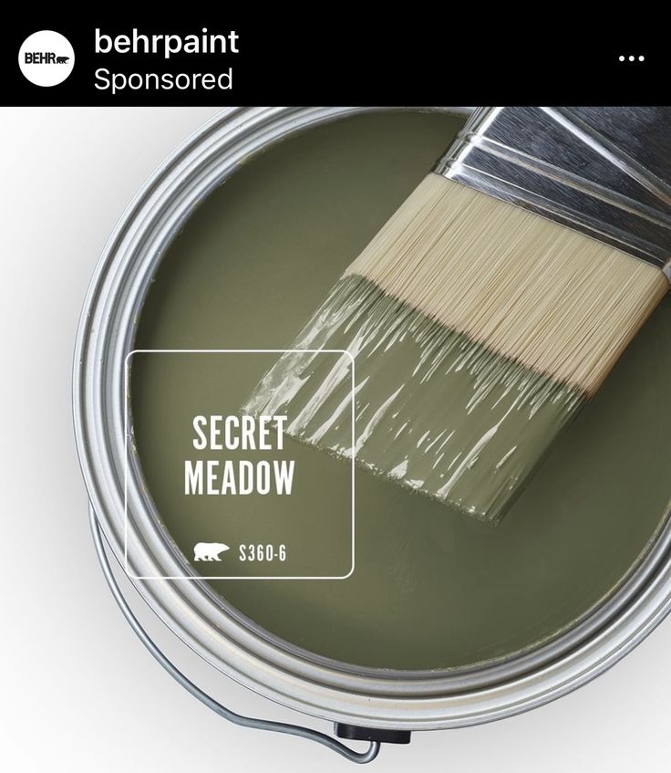 a can of paint with the words secret meadow painted on it and a brush inside