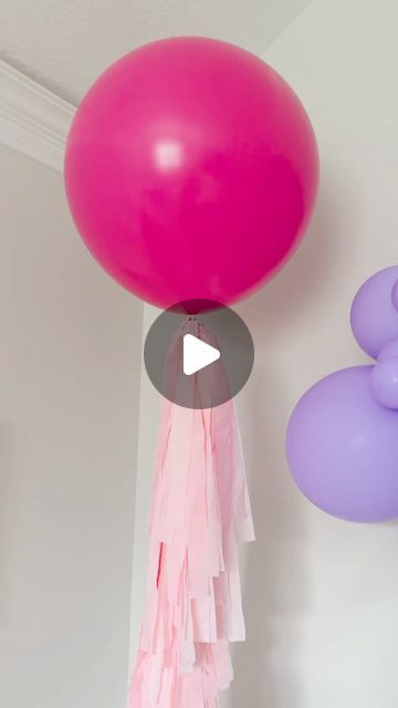 pink and purple balloons hanging from the ceiling