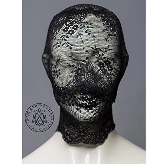 a mannequin's head is covered in black lace and has a white background