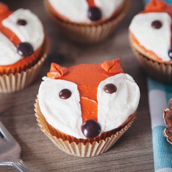 cupcakes with frosting and decorations made to look like a fox