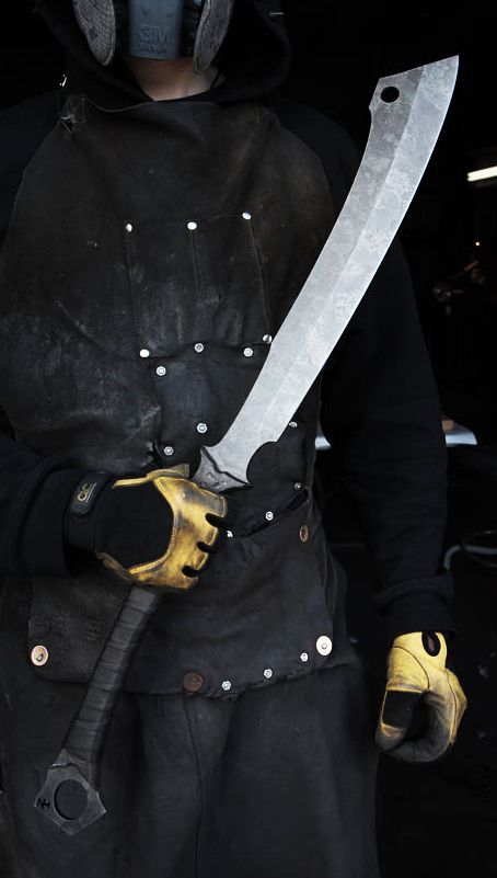 a man wearing a gas mask and holding a large knife