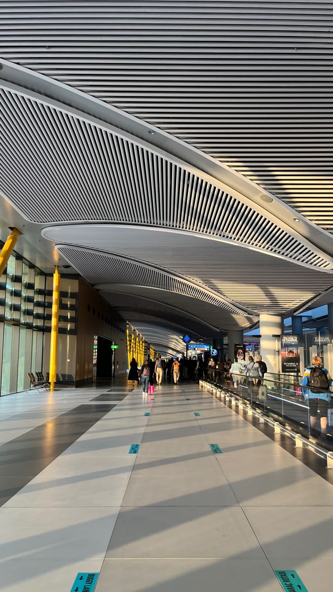 an airport terminal with people waiting for their luggage