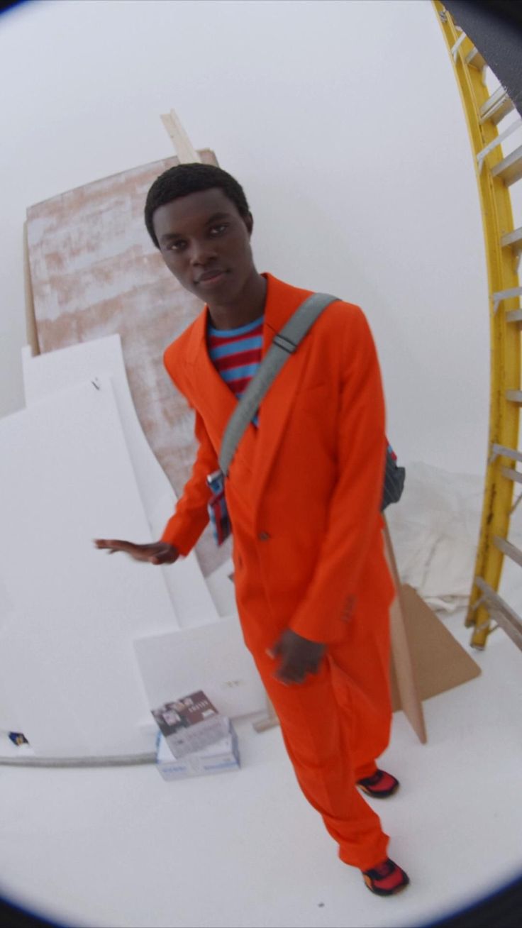 a man in an orange jumpsuit standing next to a ladder