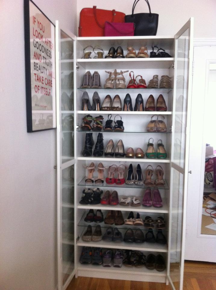 a closet filled with lots of shoes and handbags on top of shelves next to a door