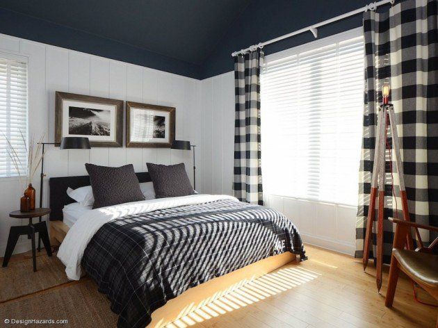 a bedroom with black and white checkered bedding, wood flooring and two framed pictures on the wall