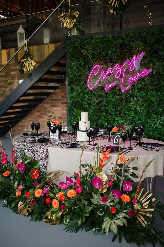 a table with flowers and candles on it in front of a green wall that says crapo's cafe