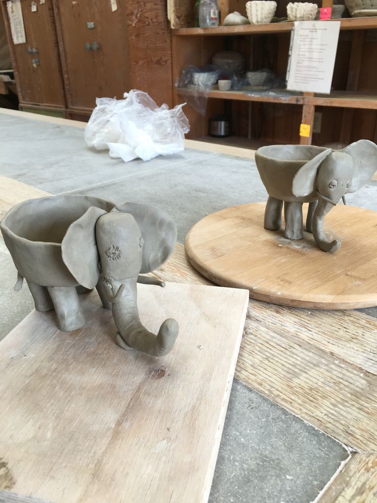 two elephant sculptures on wooden boards in a shop