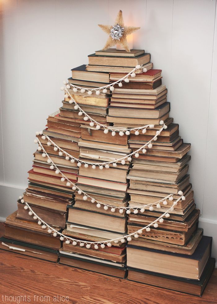 a christmas tree made out of books with lights on it and a star above the top