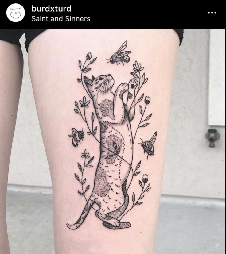 a black and white photo of a woman's thigh with an animal tattoo on it