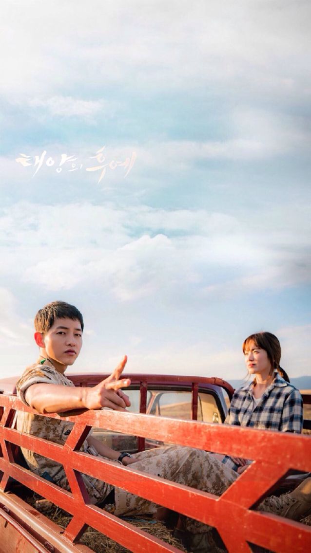 two boys sitting on the back of a pickup truck with their hands in the air