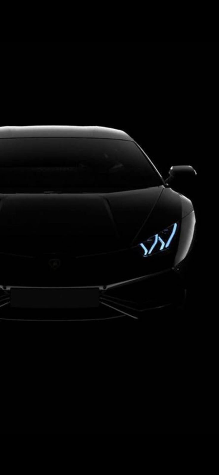 the front end of a black sports car with blue lights on it's headlights