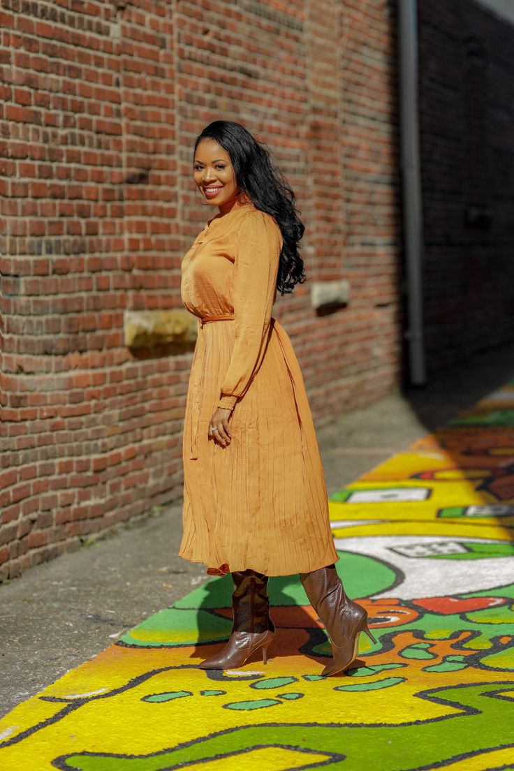 Pleated Camel Dress This pleated camel dress is a must have! Perfect for brunch, work or even a night out. You can pair with your favorite boots or sandals depending the season. This dress is a great transitional piece. Details: Gathered neck and wrists Long sleeves Comes w/ belt Comfortable Model is wearing a size small Fits true to size for most Model Measurements: Size: Medium • Height: 5'6 • Bust: 34 • Waist: 30 • Hips: 41.5 • Fall Beige Pleated Midi Dress, Fall Midi Dress For Brunch, Knee-length, Chic Orange Midi Dress For Work, Fall Brunch Midi Dress Knee-length, Fall Brunch Knee-length Midi Dress, Brown Midi Dress For Fall Day Out, Fall Pleated Solid Midi Dress, Pleated Midi Dress For Fall, Casual Pleated Midi Dress For Fall