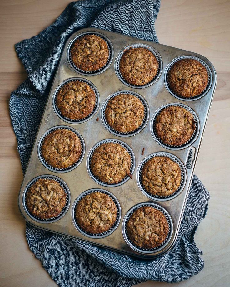 muffins in a metal pan on a wooden table with a blue cloth around them