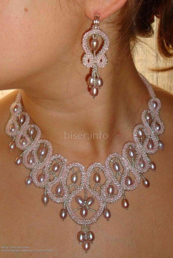 a woman wearing a necklace and earrings with pearls on the bottom of her neck,