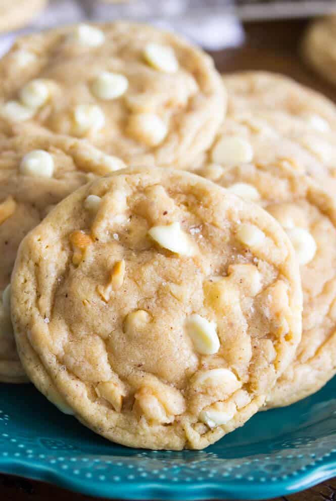 three white chocolate chip cookies on a blue plate