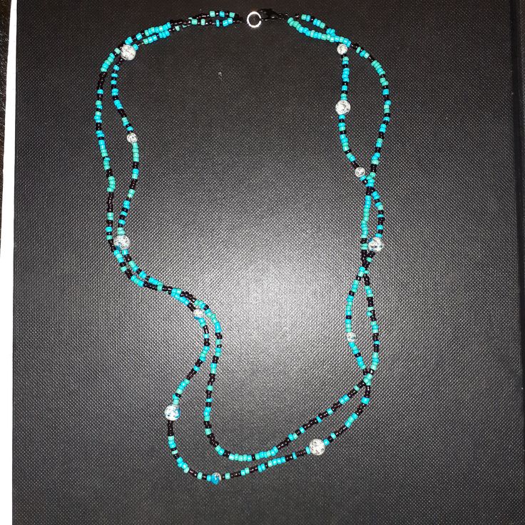 This beautiful blue necklace can be worn casually. Elegant Light Blue Necklace With Beaded Chain, Blue Jewelry With Black Beads For Beach, Elegant Blue Turquoise Necklace With Round Beads, Blue Beaded Multi-strand Crystal Necklaces, Blue Beaded Multi-strand Crystal Necklace, Blue Multi-strand Beaded Crystal Necklace, Blue Single Strand Long Beaded Necklace, Blue Long Single Strand Beaded Necklace, Elegant Blue Beach Necklace