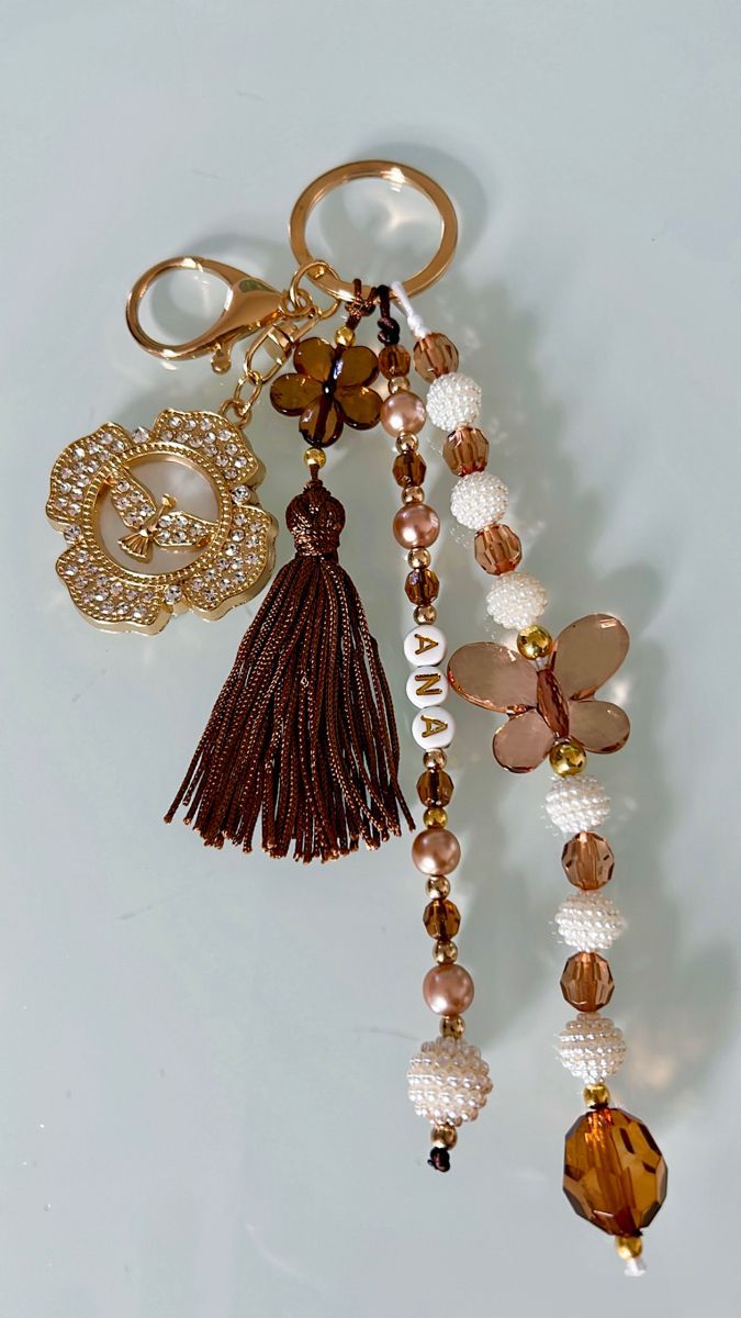 a key chain with beads and charms hanging from it's side on a white surface