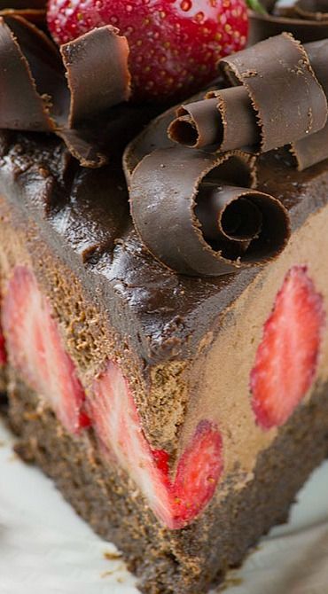 a piece of cake with chocolate and strawberries on the top is ready to be eaten