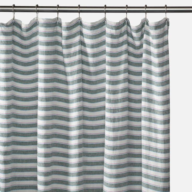 a striped curtain hanging on the side of a metal rod with a white and gray stripe pattern