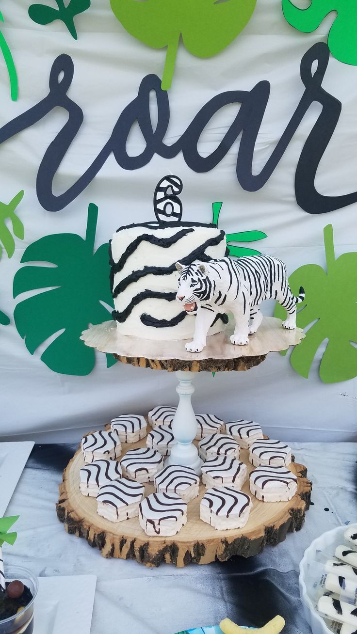 there is a zebra cake on the table with other desserts and decorations around it