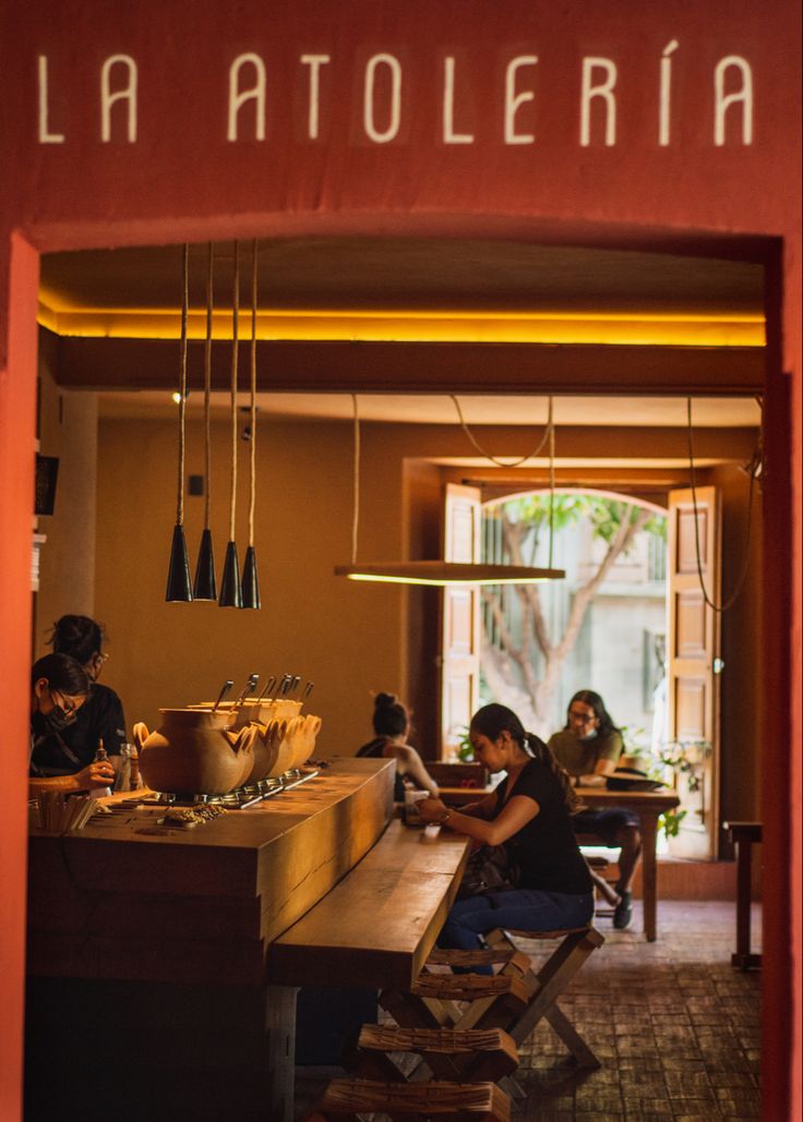 people sitting at a table in a restaurant with the name la atelierria on it