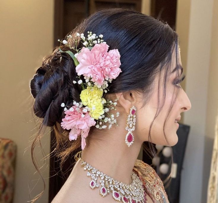 a woman with flowers in her hair and jewelry on her neck, looking off to the side