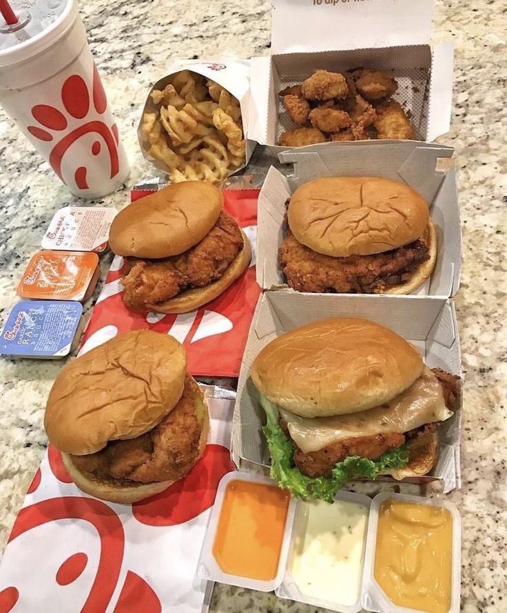 chicken sandwiches and fries are sitting on a table