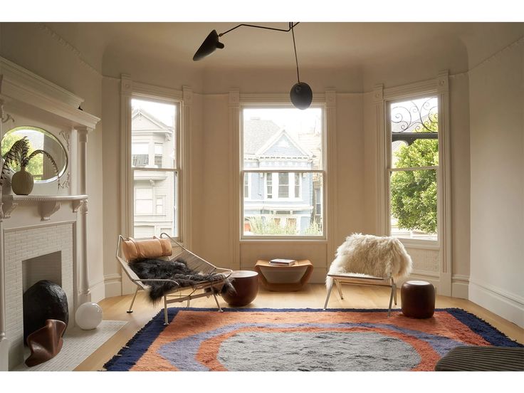 a living room filled with furniture and large windows