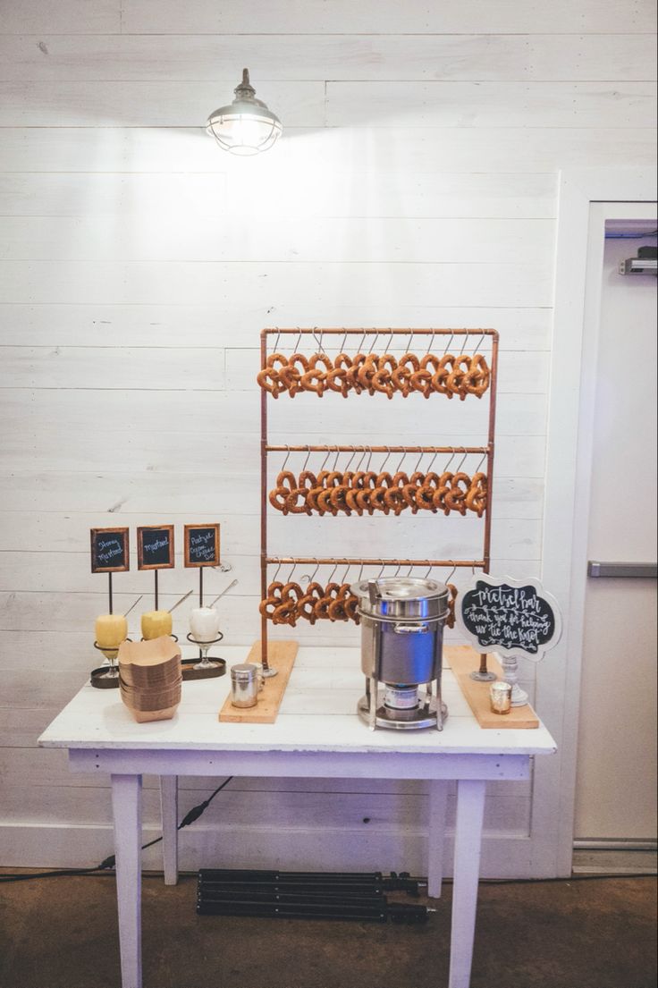 a table topped with donuts next to a chalkboard sign and light bulb fixture