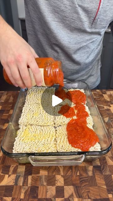 someone is spreading sauce on top of pasta