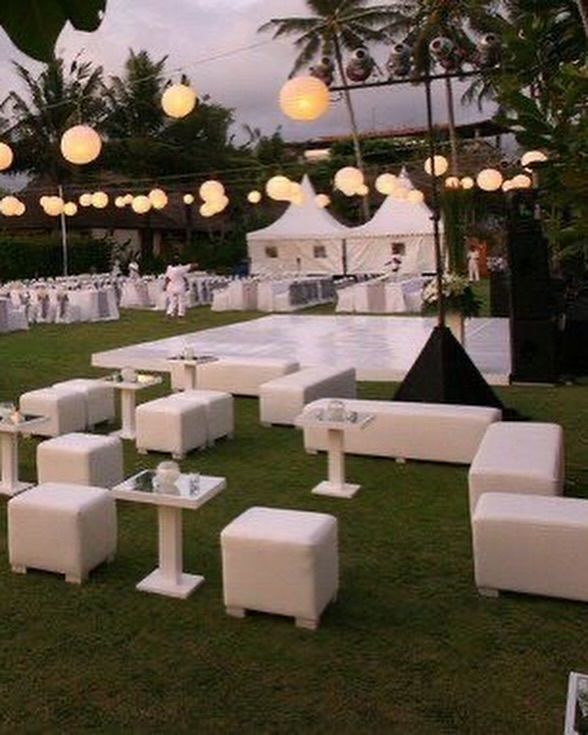 tables and chairs are set up on the lawn for an outdoor wedding reception at dusk